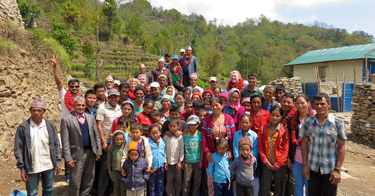A group of villagers in Chheskam, Nepal high in the Himalayas holding a school opening ceremony and celebrating Mexicali Blues for their project sponsorship
