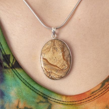 jasper pendant hanging on a neck with a hint of a tie dye dress showing