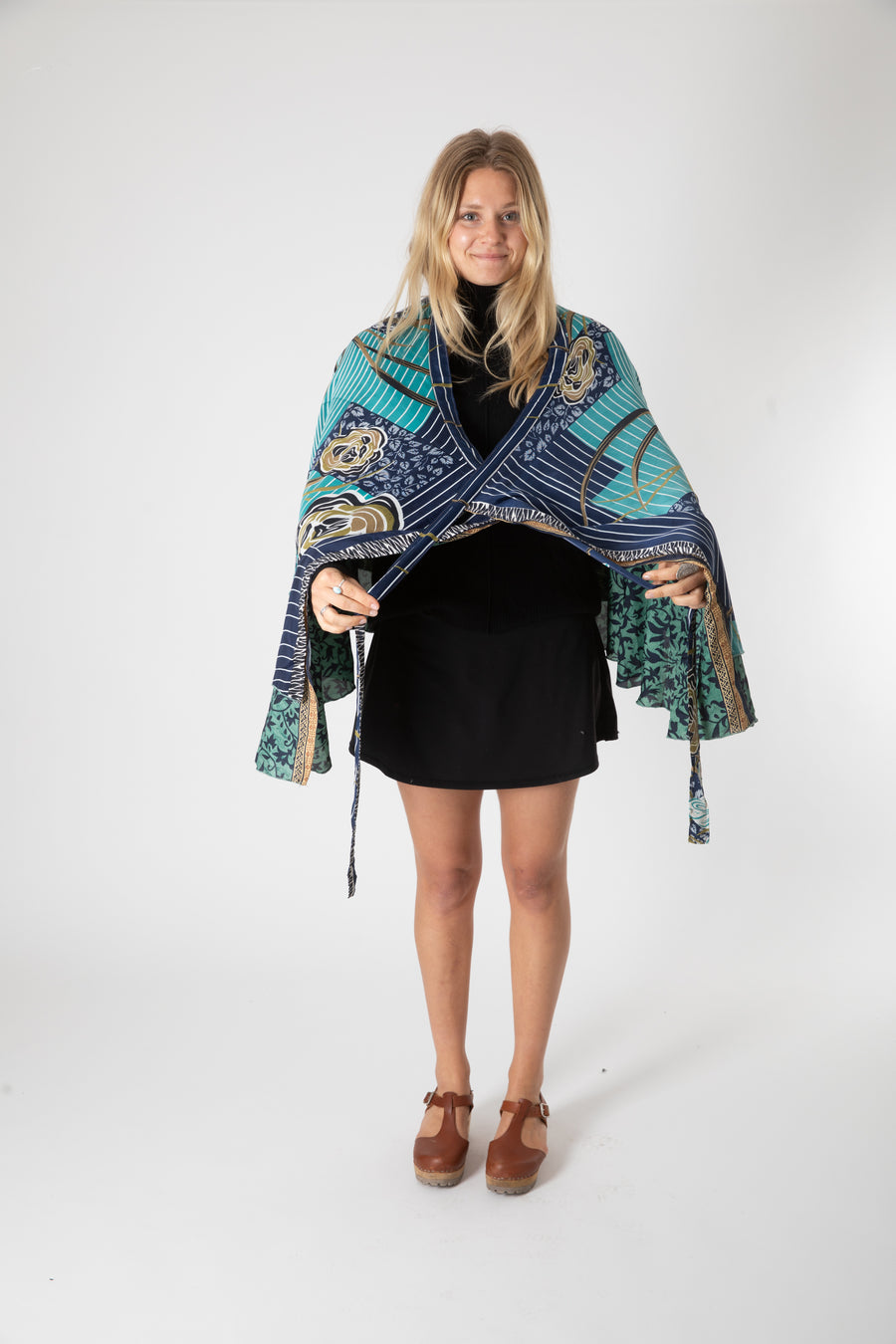 Beautiful blonde hippie girl wearing a teal recycled silk magic skirt as a boho hippie style shrug