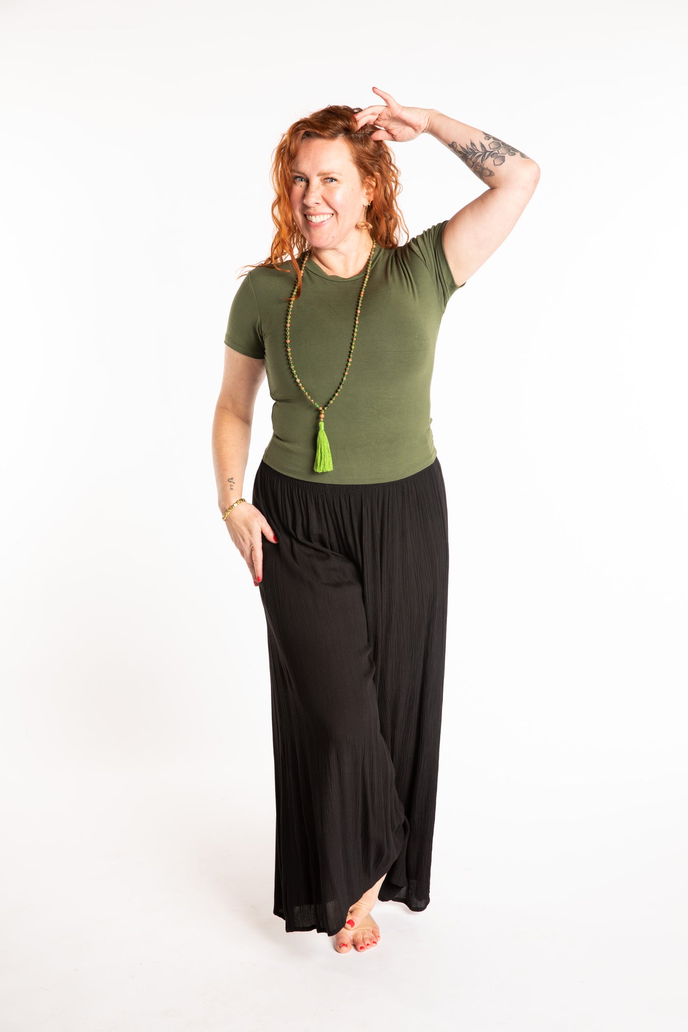 Maggie is wearing the M/L Green Chara Crew Neck Top