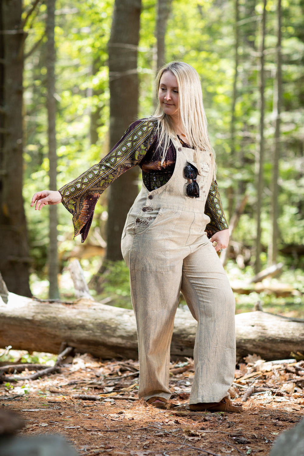 Free spirited hippie in the forest wearing mushroom overalls handmade in Nepal