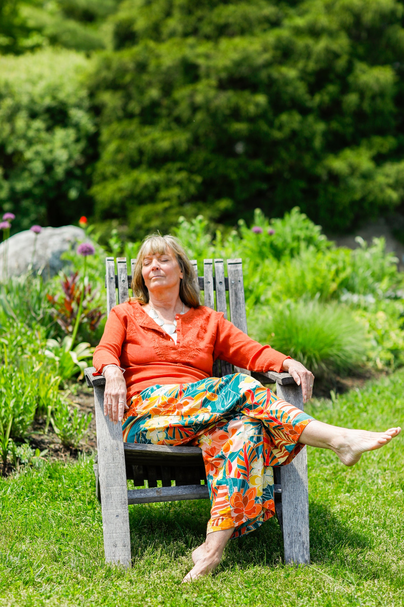 Woman wearing printed pants, relaxing in chair