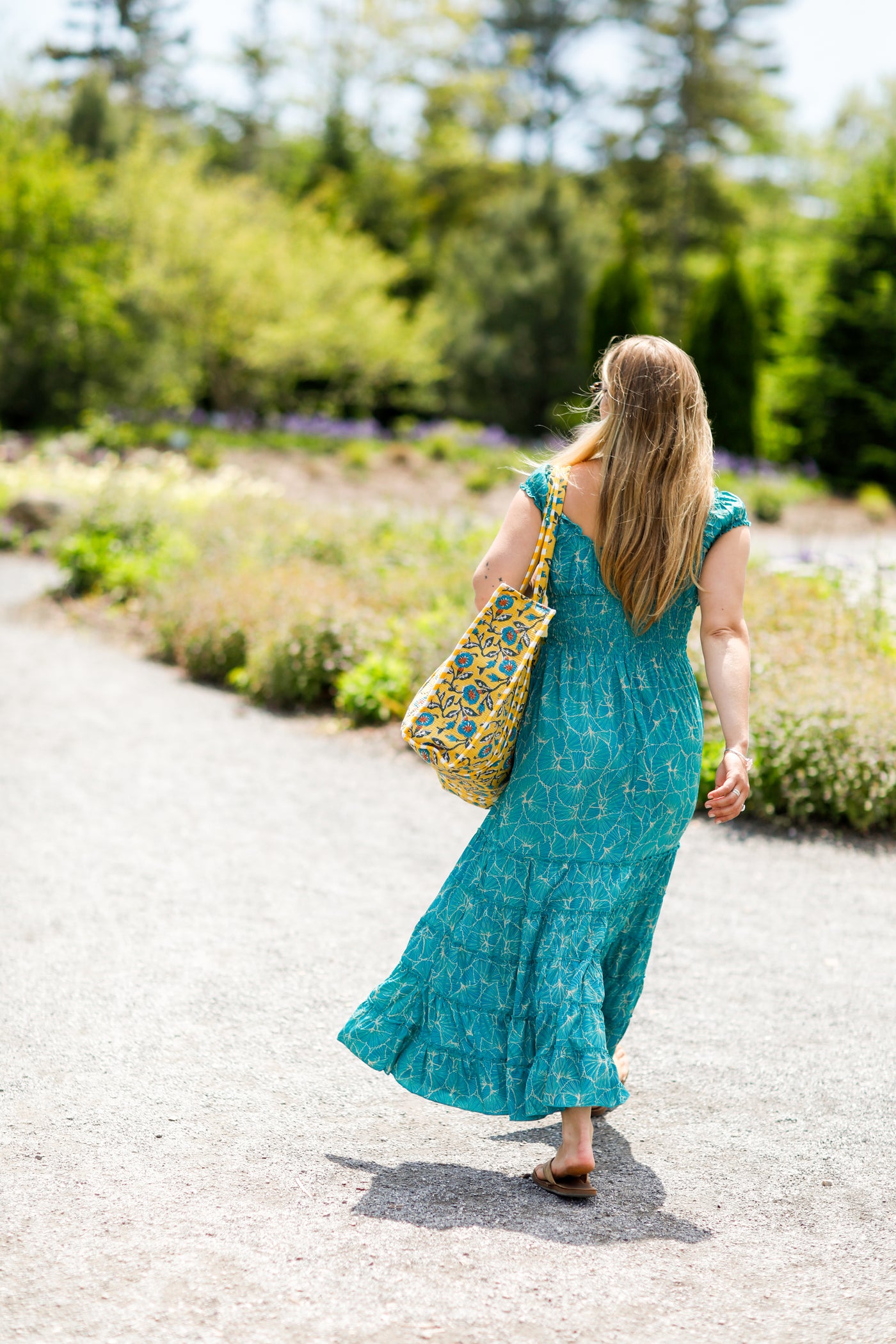 Woman in silk dress walking with block print bag