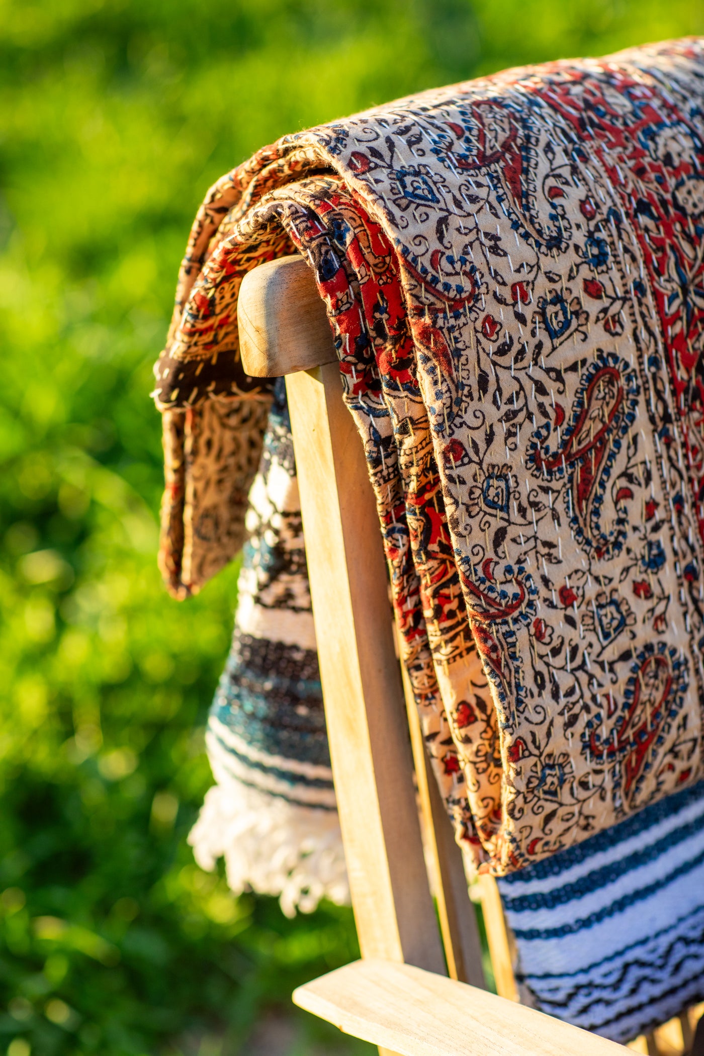 Gudri Block Print Bedspread in multicolor draped over a chairback.