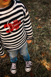 River is wearing a kids lobster sweater
