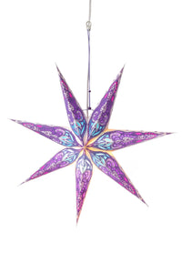 A purple patterned paper star lantern with a white backdrop. 