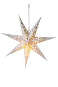 A white glowing paper lantern in the shape of a star illuminated in front of a white backdrop. 