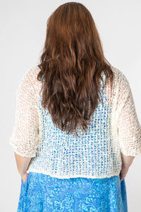 Sarah wearing a ivory lightweight knitted poncho with a solid pattern.
