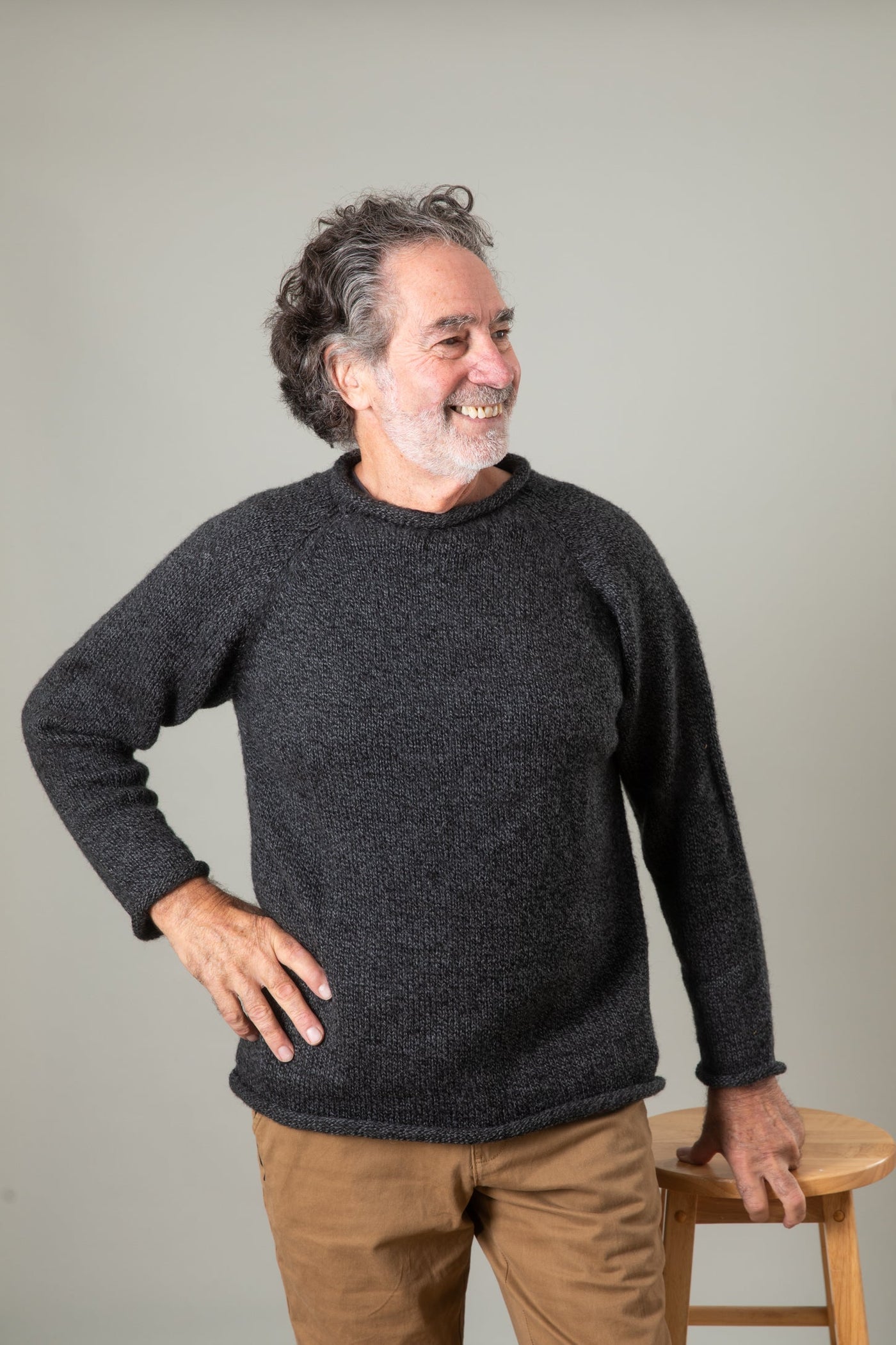Bernie is wearing the size L Classic Unisex Alpaca Wool Sweater in Charcoal