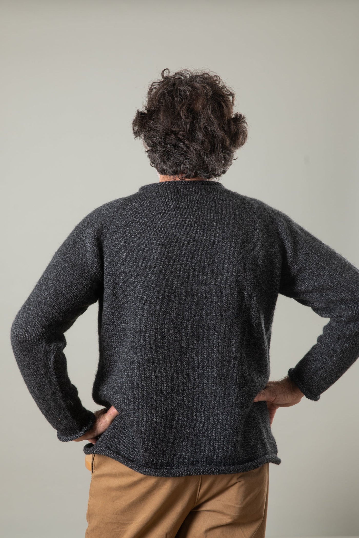 Bernie is wearing the size L Classic Unisex Alpaca Wool Sweater in Charcoal