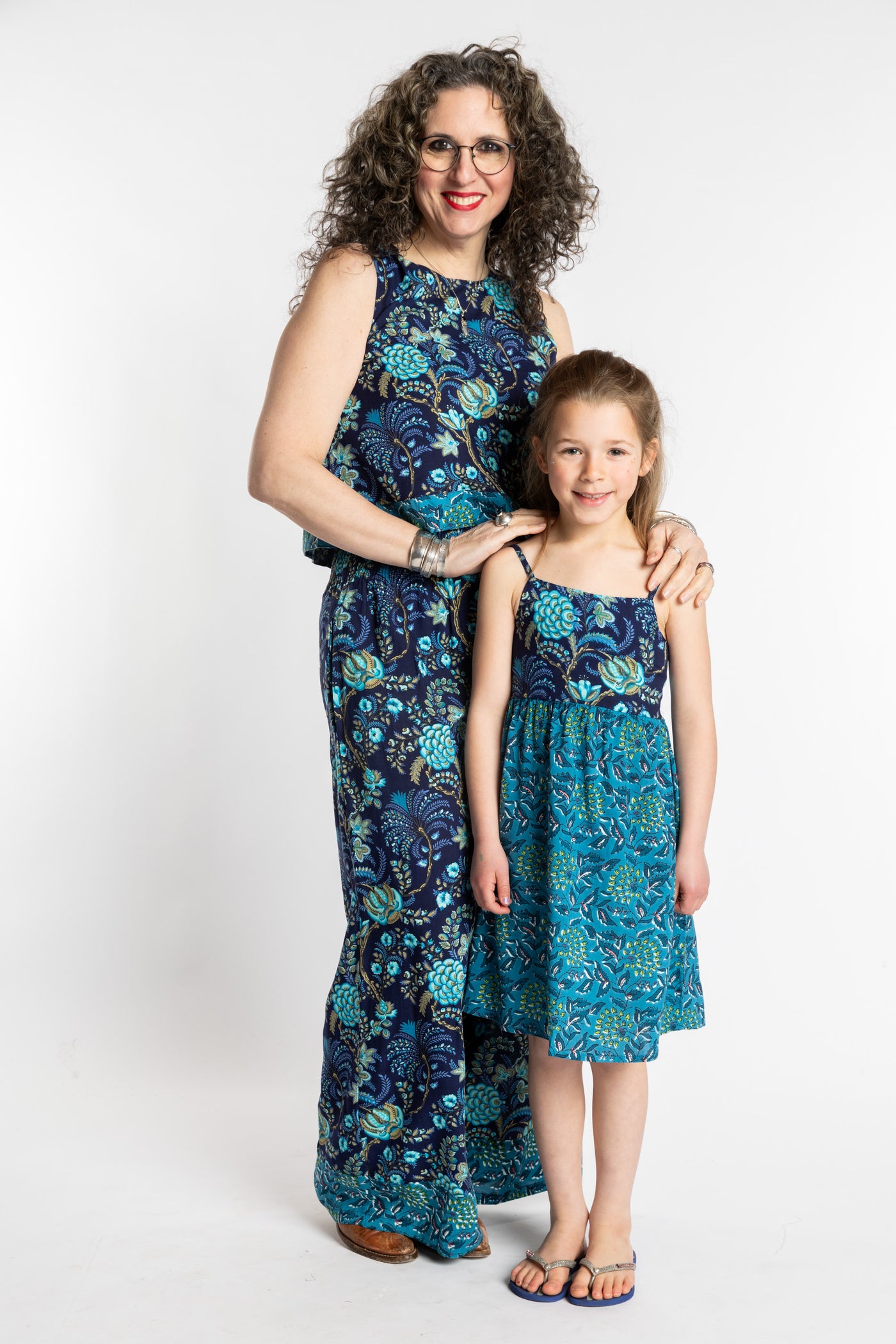 Susan wearing the Sahana Contrast Hem Sleeveless Top and Penny Lane Contrast Hem Pants with Louisa in the matching Flora Fusion Kids Dress