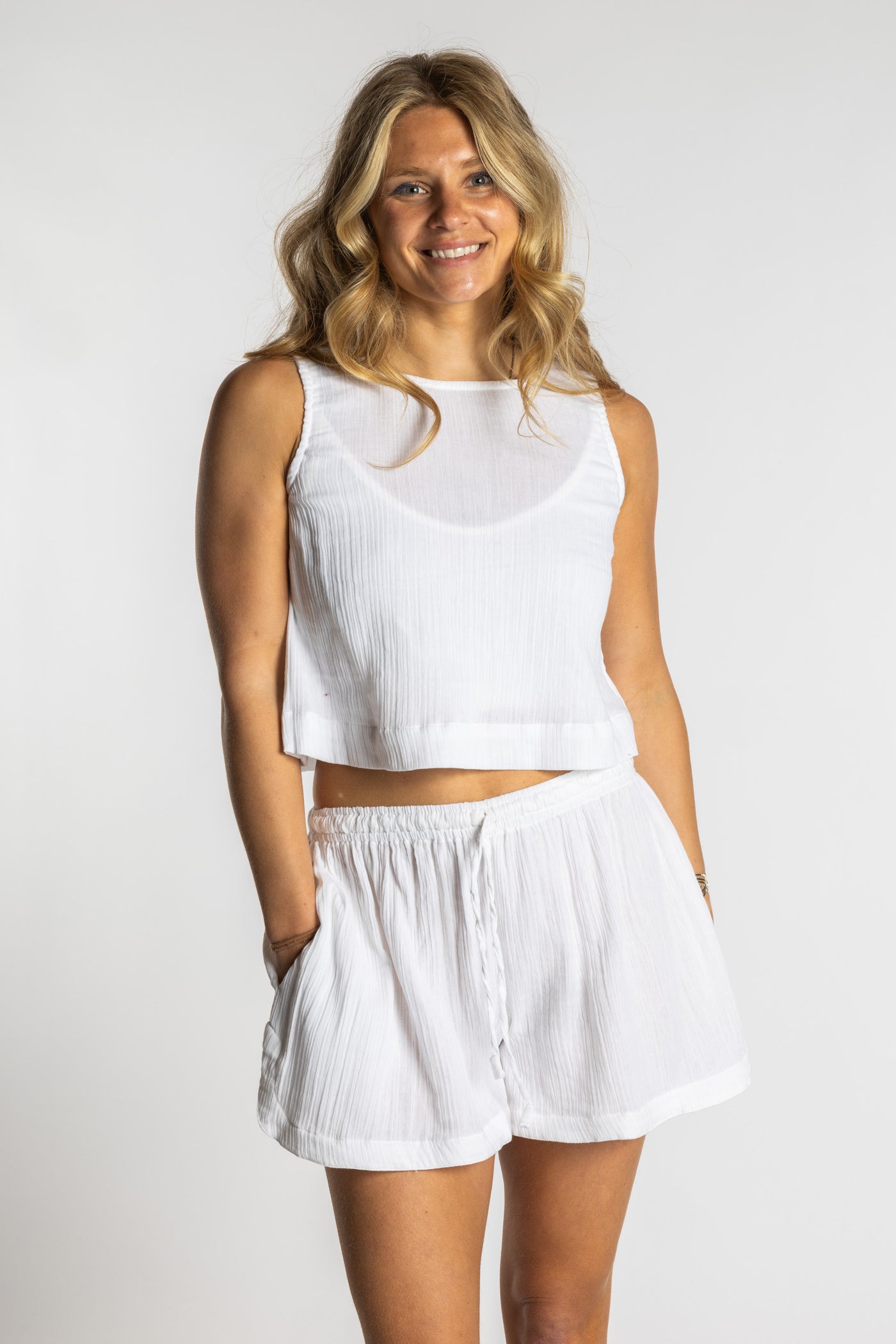 Sophie wearing a white ivory cotton summer matching set with sleeveless crop top and drawstring shorts, size S/M