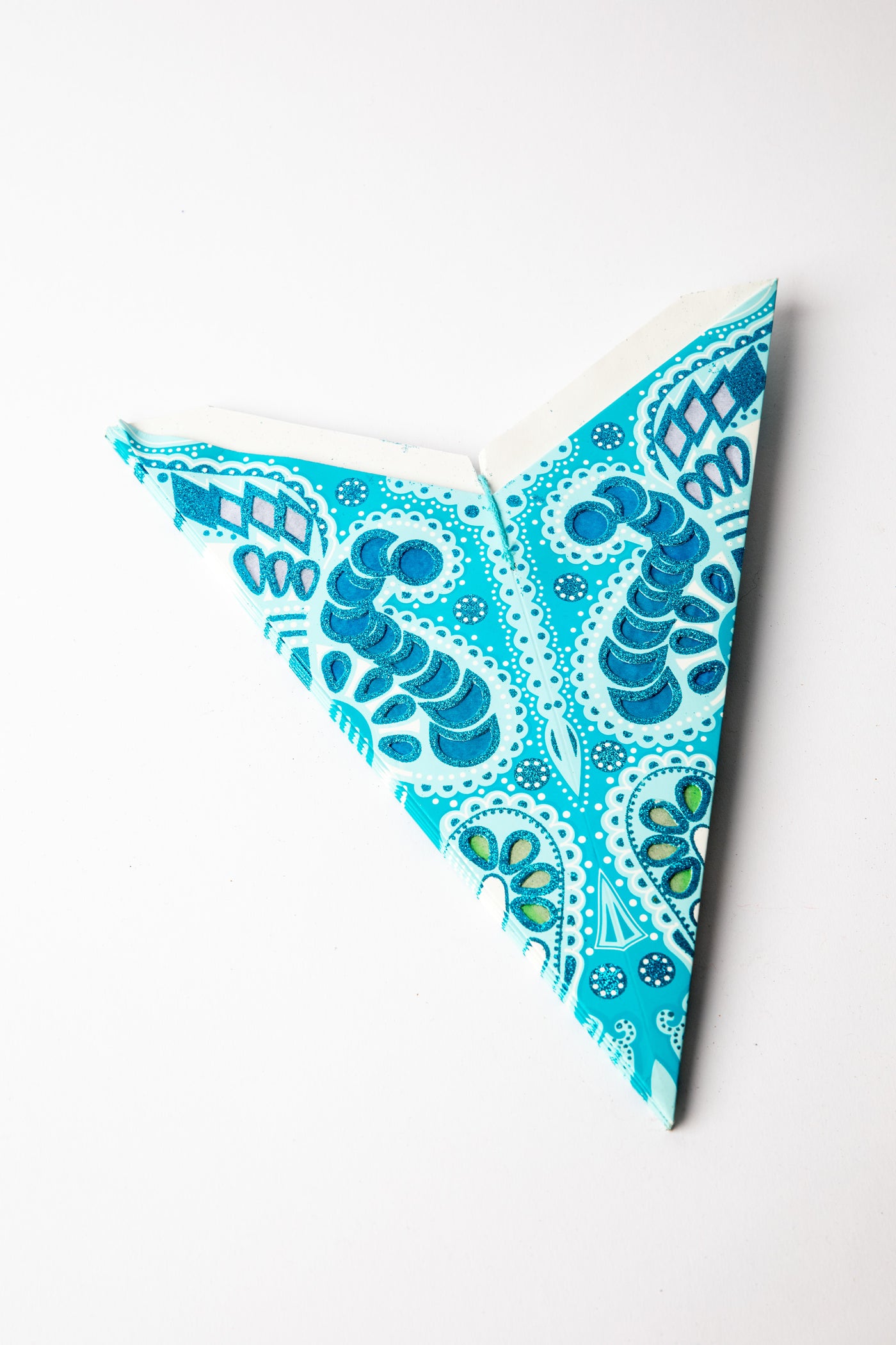 Turquoise Zari embroidered paper star folded up, out of the package