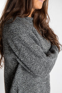Jen wearing a size large black and white fisherman style sweater 