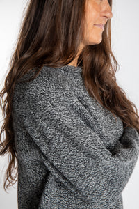 Jen wearing a size large black and white fisherman style sweater 