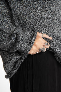 Jen wearing a size large black and white fisherman style sweater 