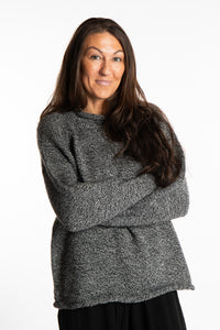 Jen wearing a size large black and white fisherman style sweater 