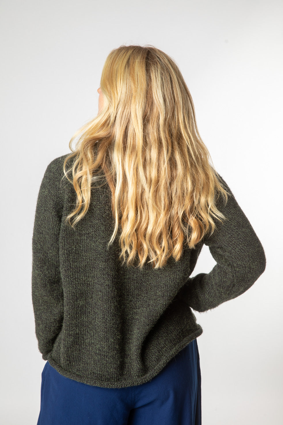 Sophie is wearing size S roll neck alpaca sweater in dark green 