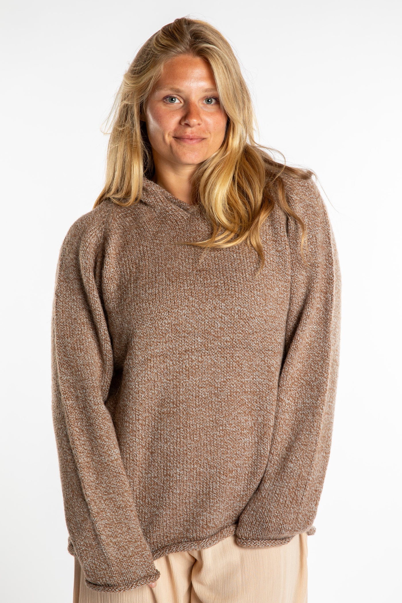 Sophie is wearing a size L hooded alpaca sweater in Tan