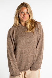 Sophie is wearing a size L hooded alpaca sweater in Tan