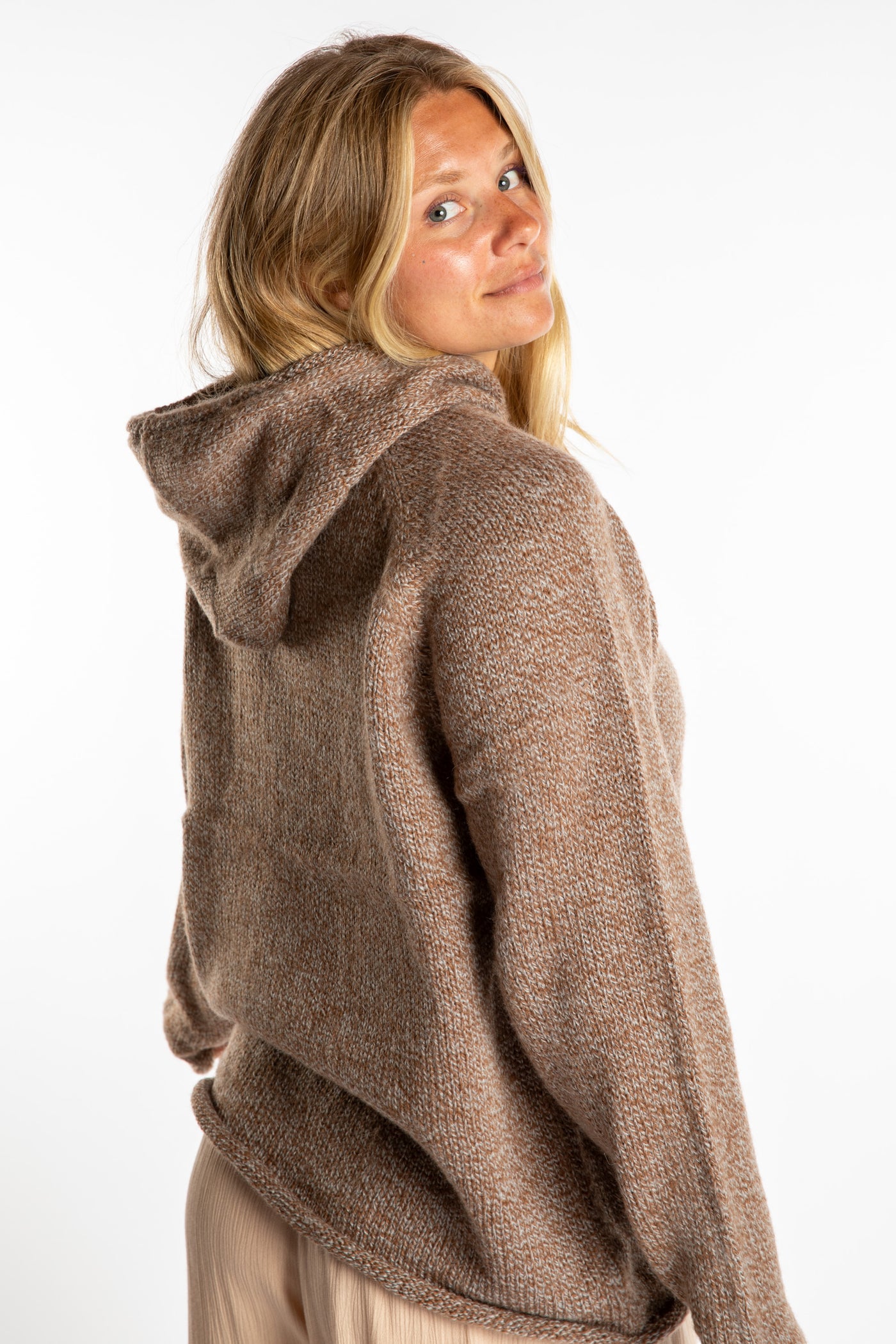 Sophie is wearing a size L hooded alpaca sweater in Tan
