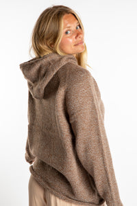Sophie is wearing a size L hooded alpaca sweater in Tan