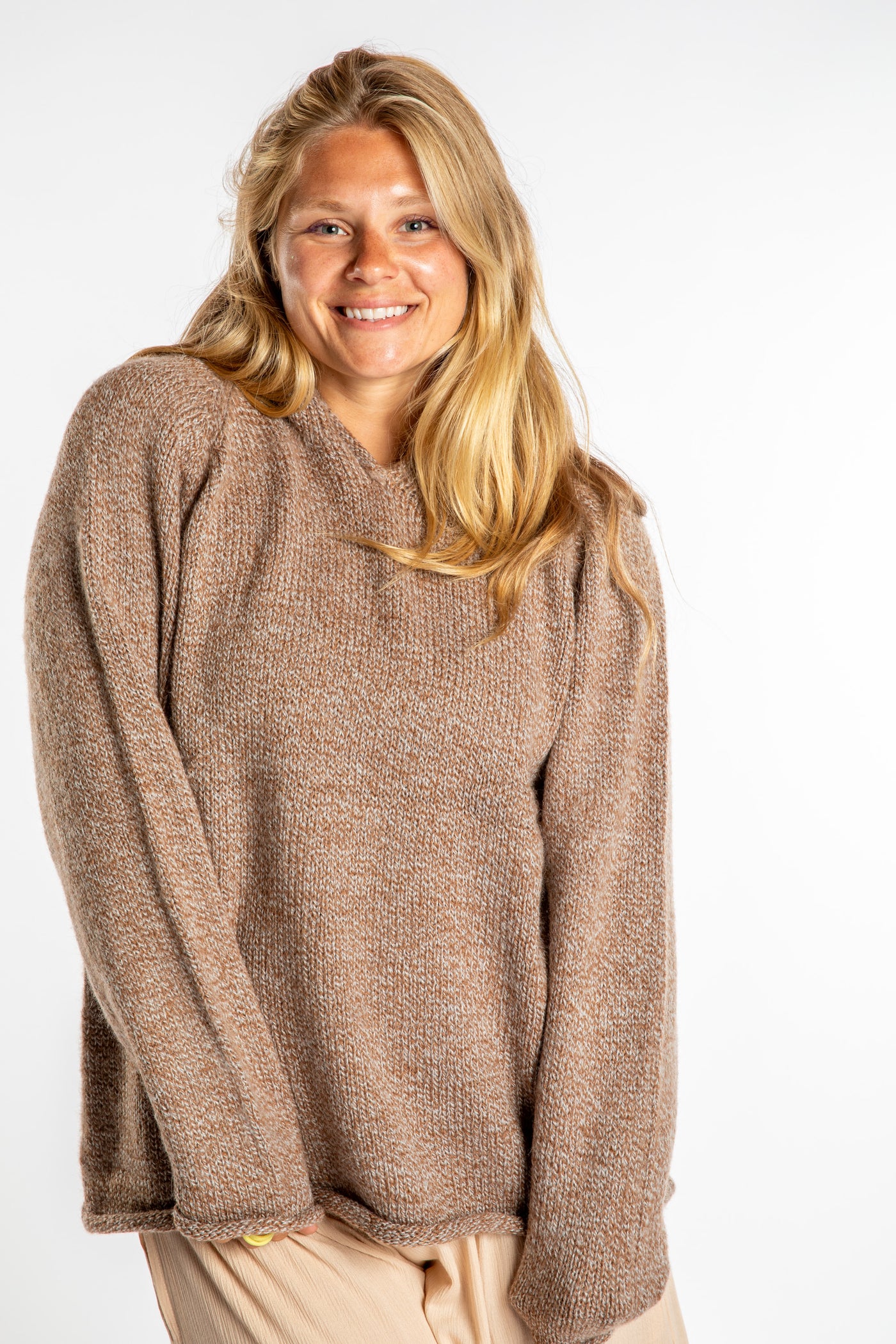 Sophie is wearing a size L hooded alpaca sweater in Tan