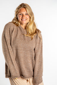 Sophie is wearing a size L hooded alpaca sweater in Tan