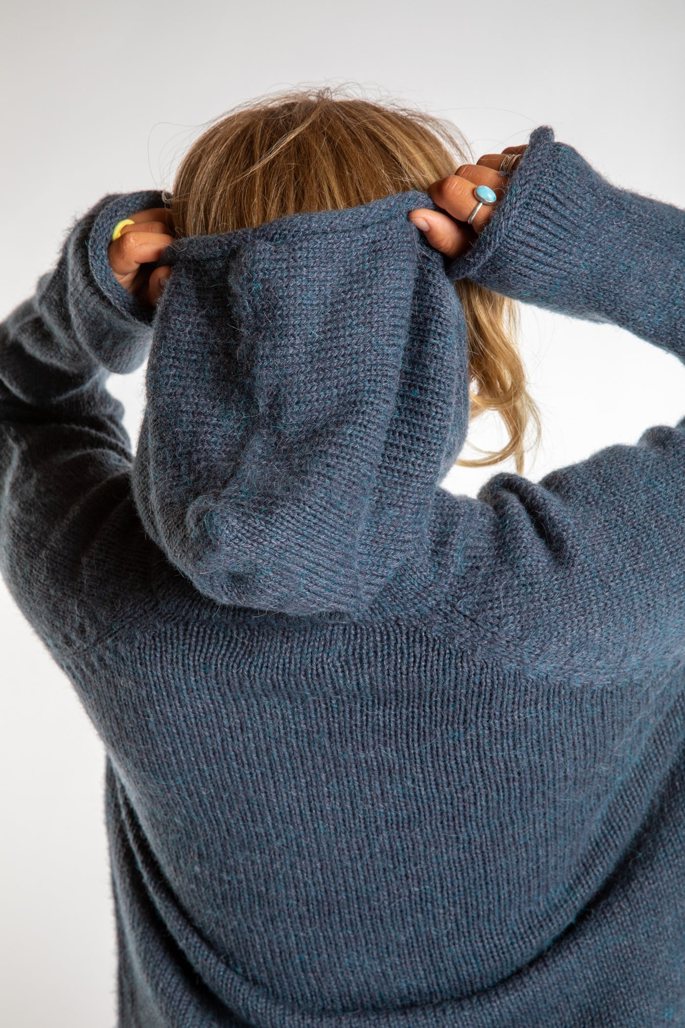 Sophie is wearing a size M hooded alpaca sweater in Vintage Denim blue