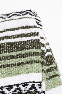 Striped recycled blanket with green, white, and black pattern on a white background