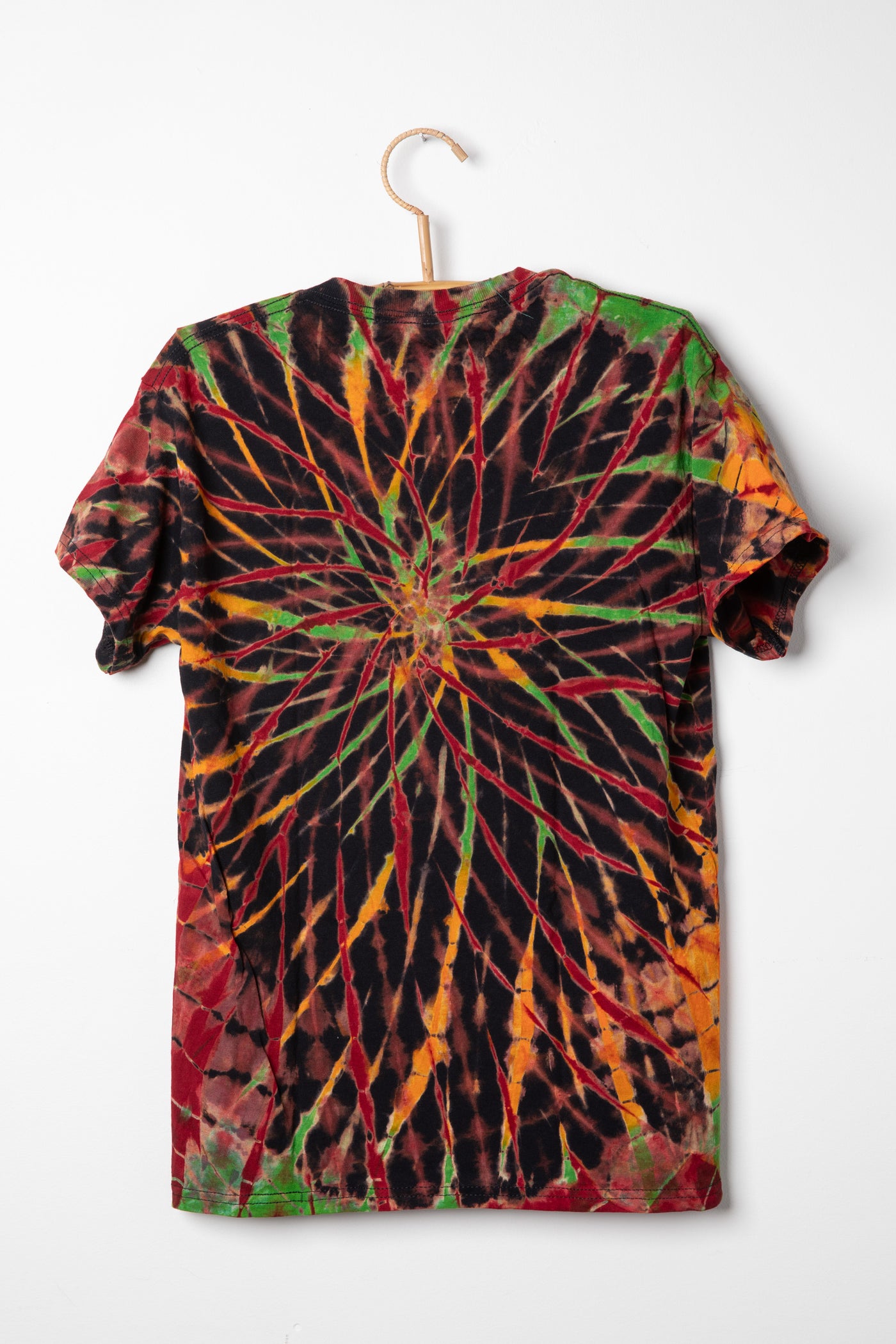 Tie-dye Rasta colored t-shirt with a spiral pattern on a white background