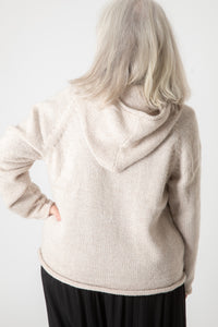 Toni, wearing size S, wearing an oatmeal alpaca wool pullover sweater with a hood.