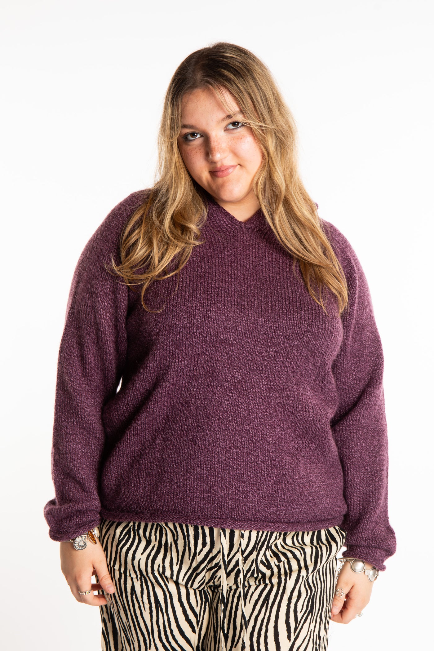 Emma is wearing a size L hooded alpaca sweater in Plum