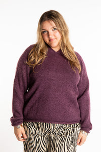 Emma is wearing a size L hooded alpaca sweater in Plum