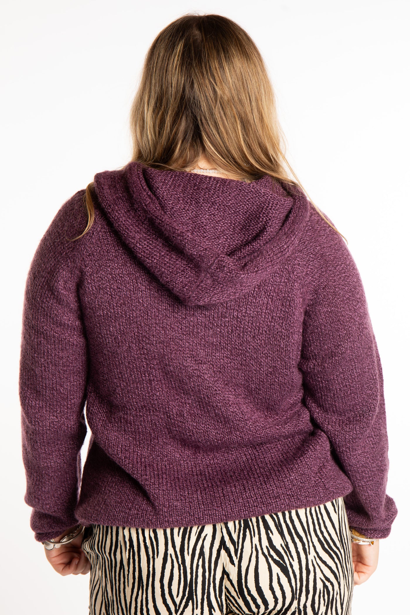 Emma is wearing a size L hooded alpaca sweater in Plum