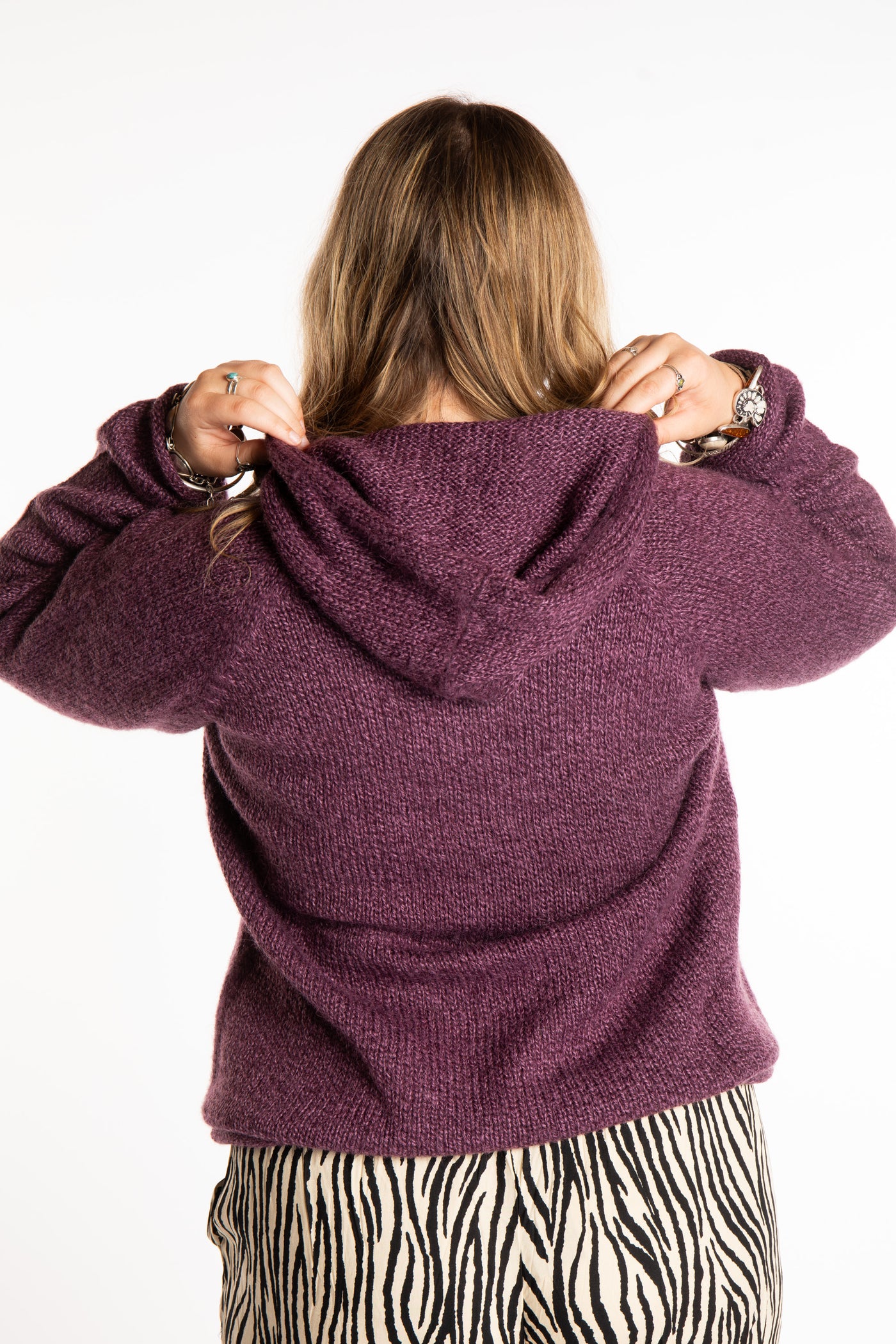 Emma is wearing a size L hooded alpaca sweater in Plum