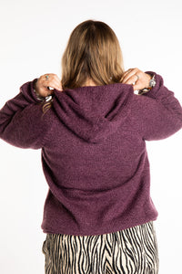 Emma is wearing a size L hooded alpaca sweater in Plum