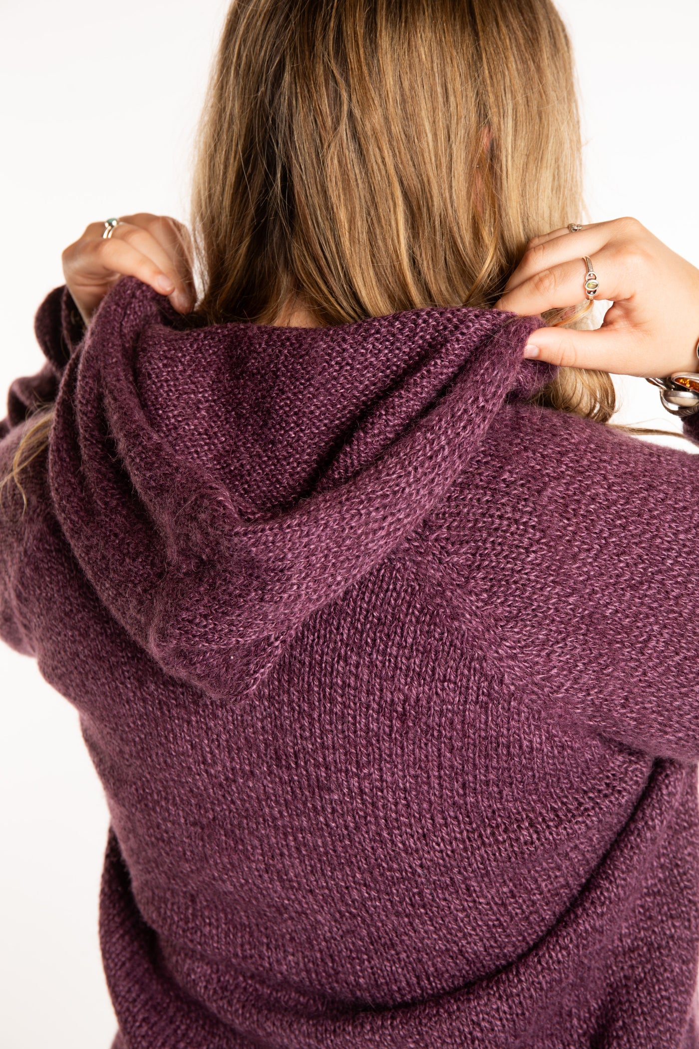 Emma is wearing a size L hooded alpaca sweater in Plum