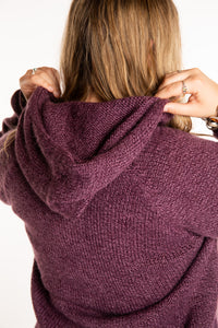 Emma is wearing a size L hooded alpaca sweater in Plum