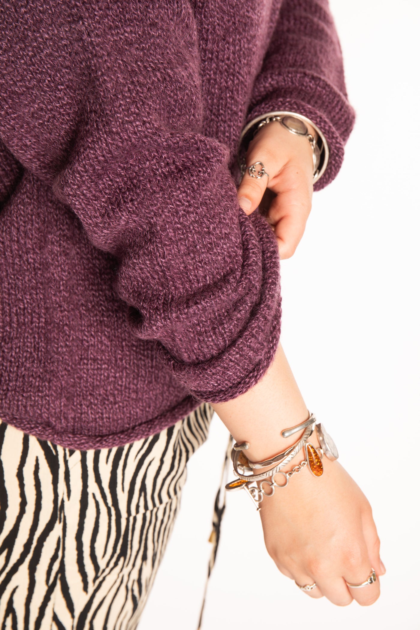 Emma is wearing a size L hooded alpaca sweater in Plum