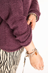 Emma is wearing a size L hooded alpaca sweater in Plum