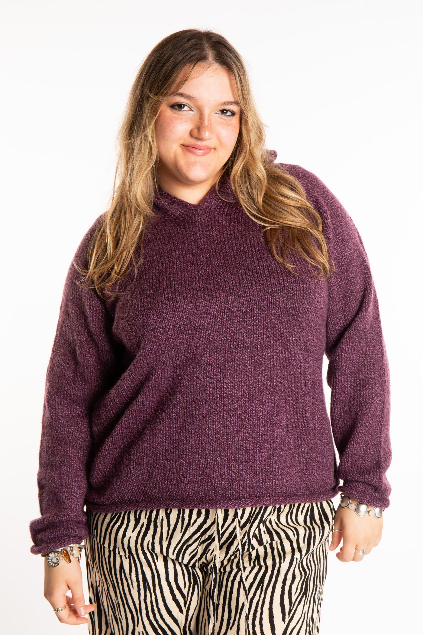 Emma is wearing a size L hooded alpaca sweater in Plum