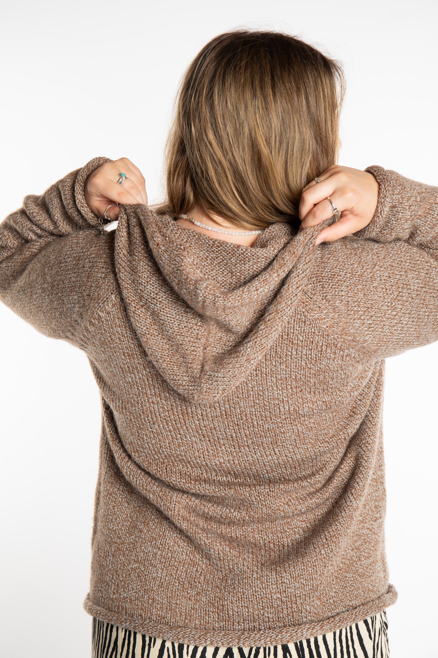 Emma is wearing a size L hooded alpaca sweater in Tan