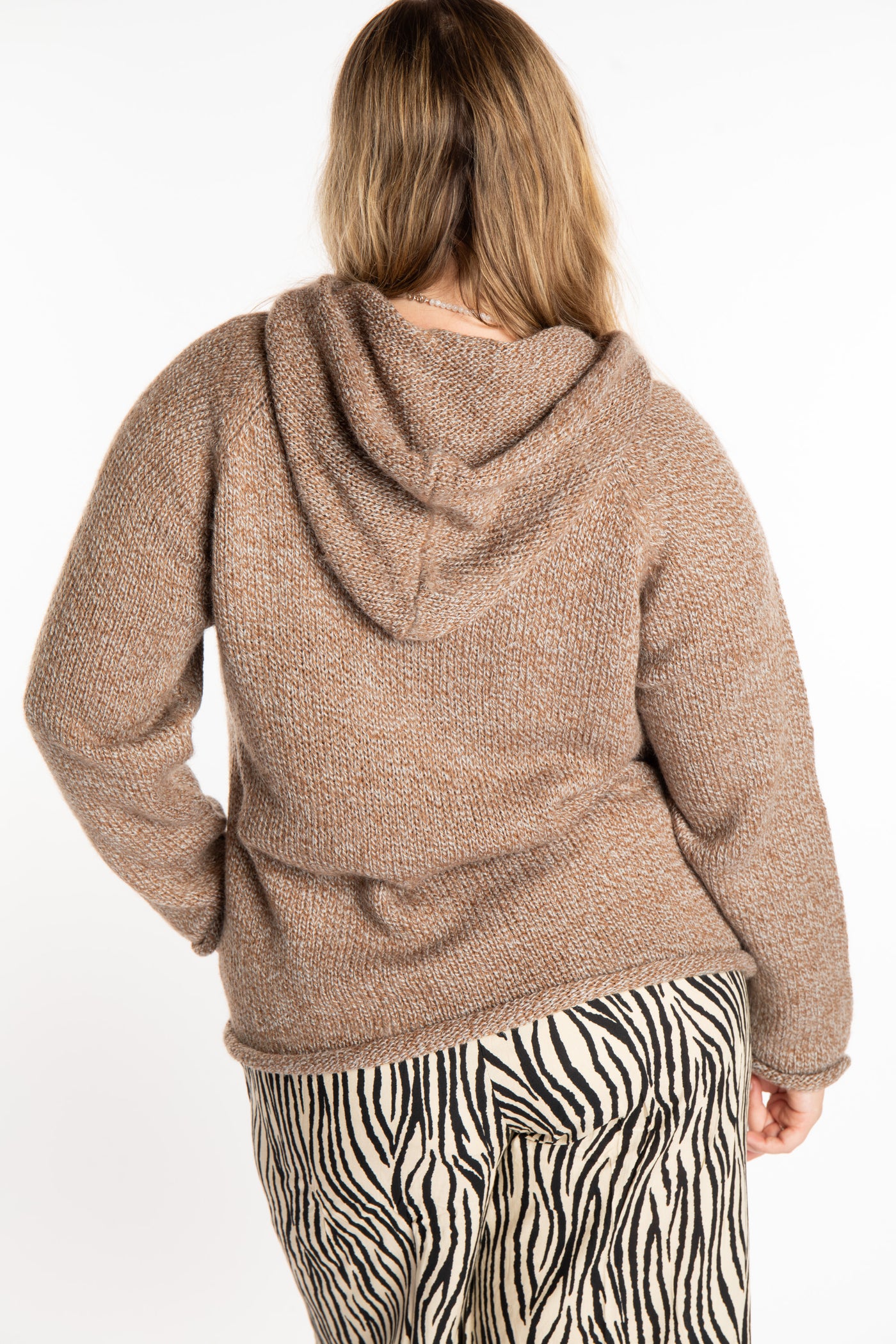 Emma is wearing a size L hooded alpaca sweater in Tan