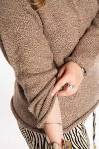 Emma is wearing a size L hooded alpaca sweater in Tan