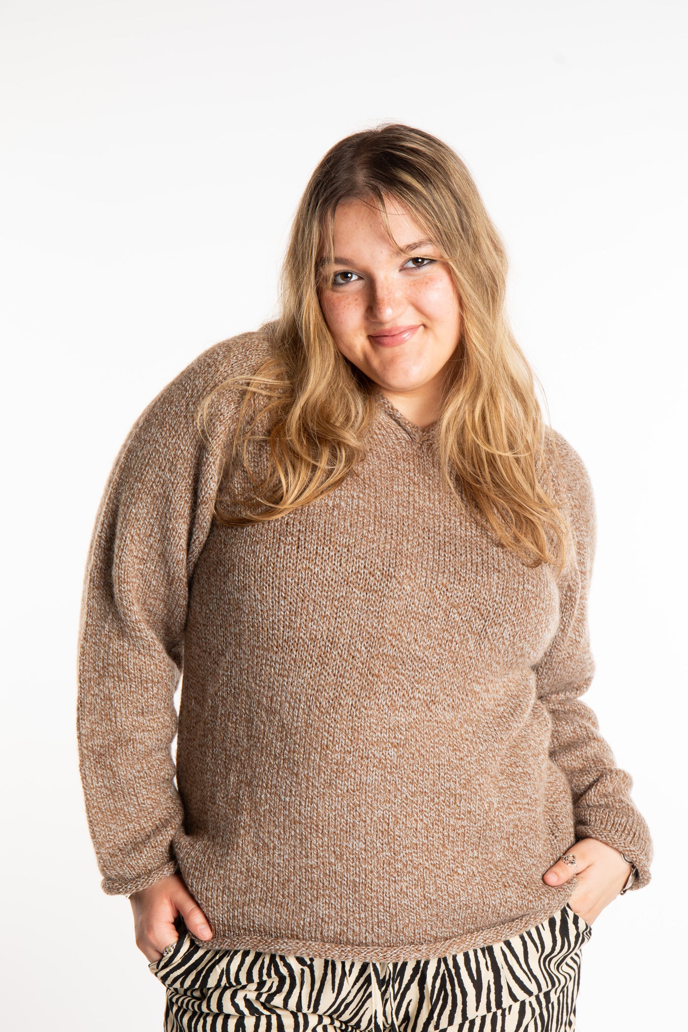 Emma is wearing a size L hooded alpaca sweater in Tan