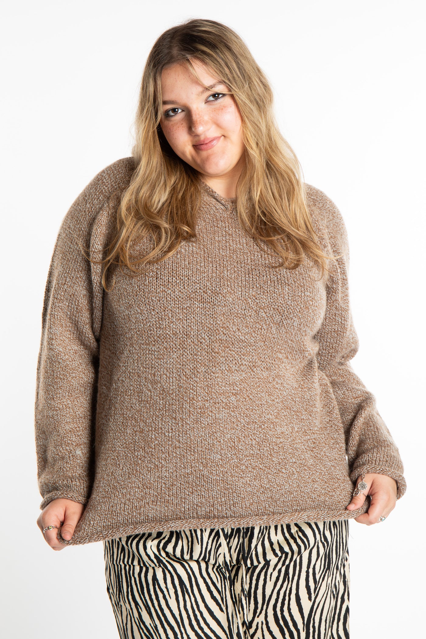 Emma is wearing a size L hooded alpaca sweater in Tan