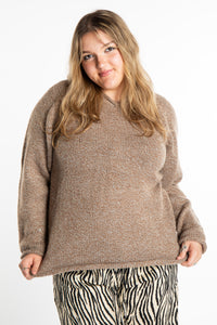Emma is wearing a size L hooded alpaca sweater in Tan