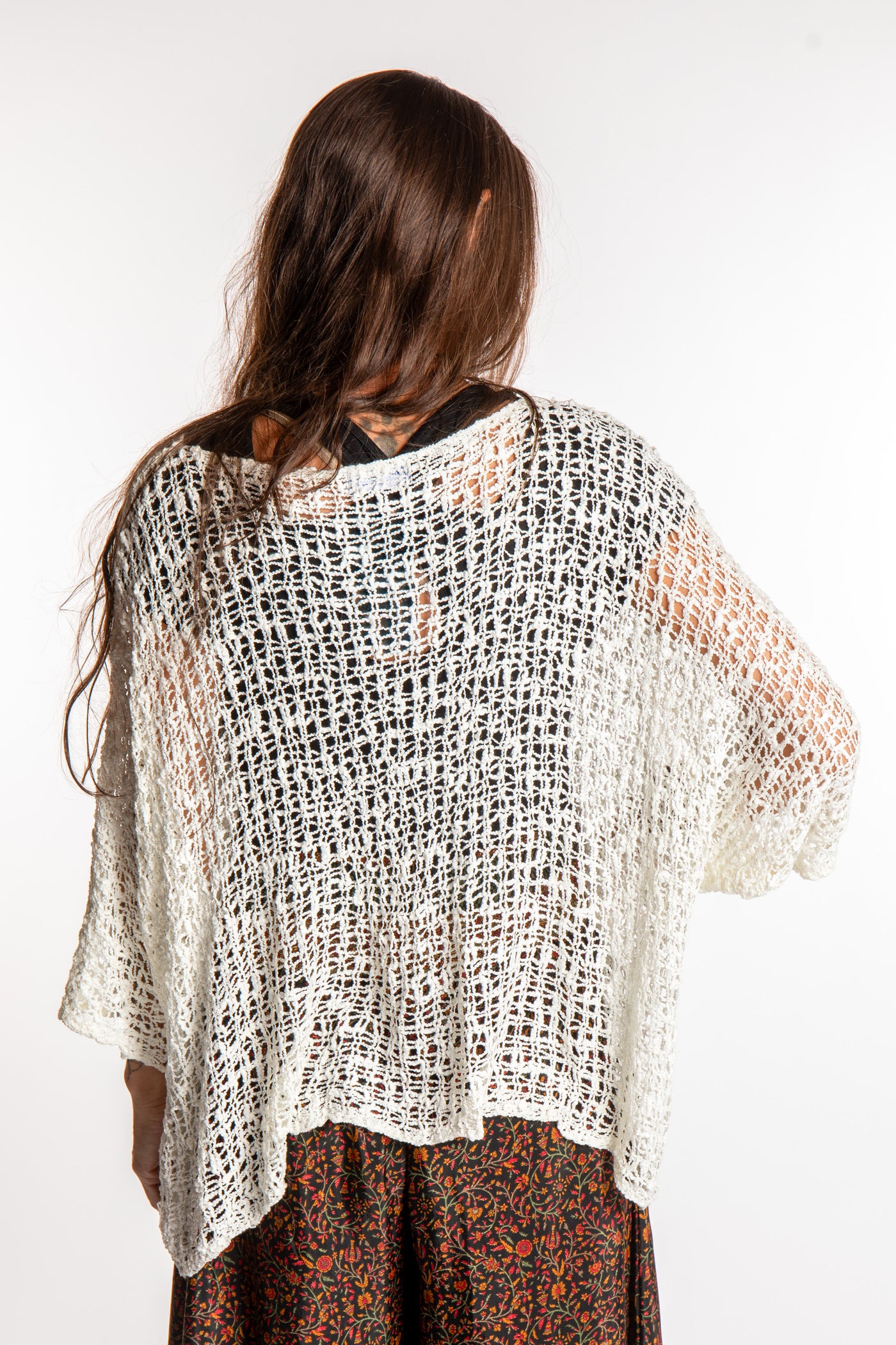 Jen wearing a ivory lightweight knitted poncho
