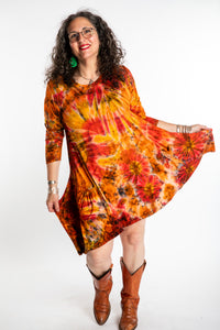 Susan wearing a orange long sleeve tie dye dress in the color Sunset